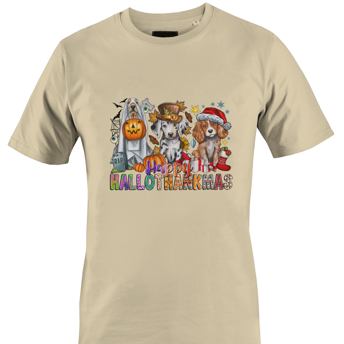 A beige crewneck t-shirt featuring a colorful graphic print of three dogs dressed in Halloween costumes with the text 'Happy HALLOTHANKSMAS'.