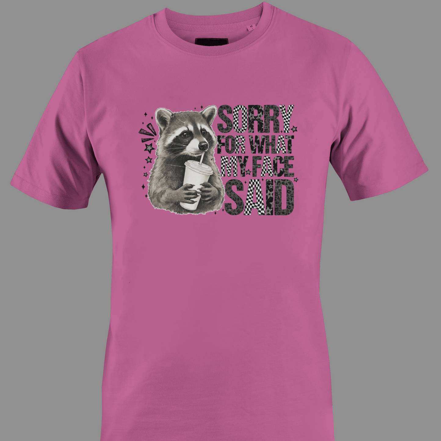 Dark pink t-shirt with a raccoon graphic and text sorry for what my face said