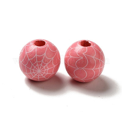 Painted round pink wooden beads with white cobwebs for crafting and wreath making.