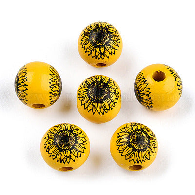 Yellow painted round wooden beads with black sunflower pattern for crafting and wreath making.