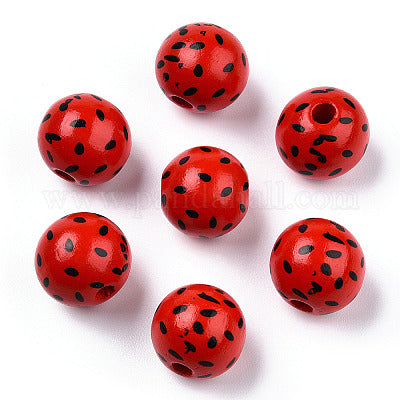 Painted red wooden beads with black seeds imitating a watermelon for crafting and wreath making