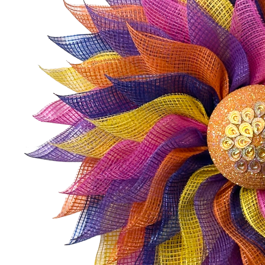 Deco mesh flower wreath with multicolored petals and an orange gemstone flower center