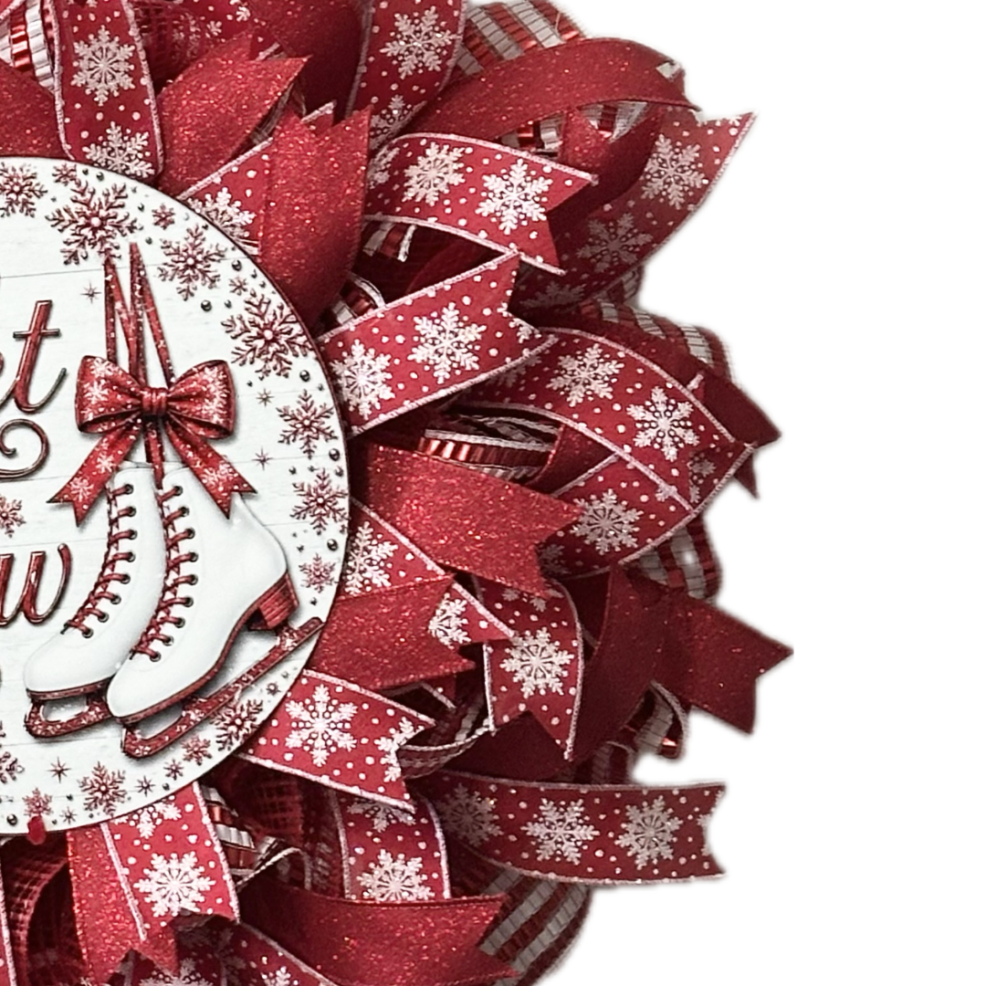 Red and white deco mesh and ribbon wreath featuring ice skates and "let it snow" by Monkey's Creations.