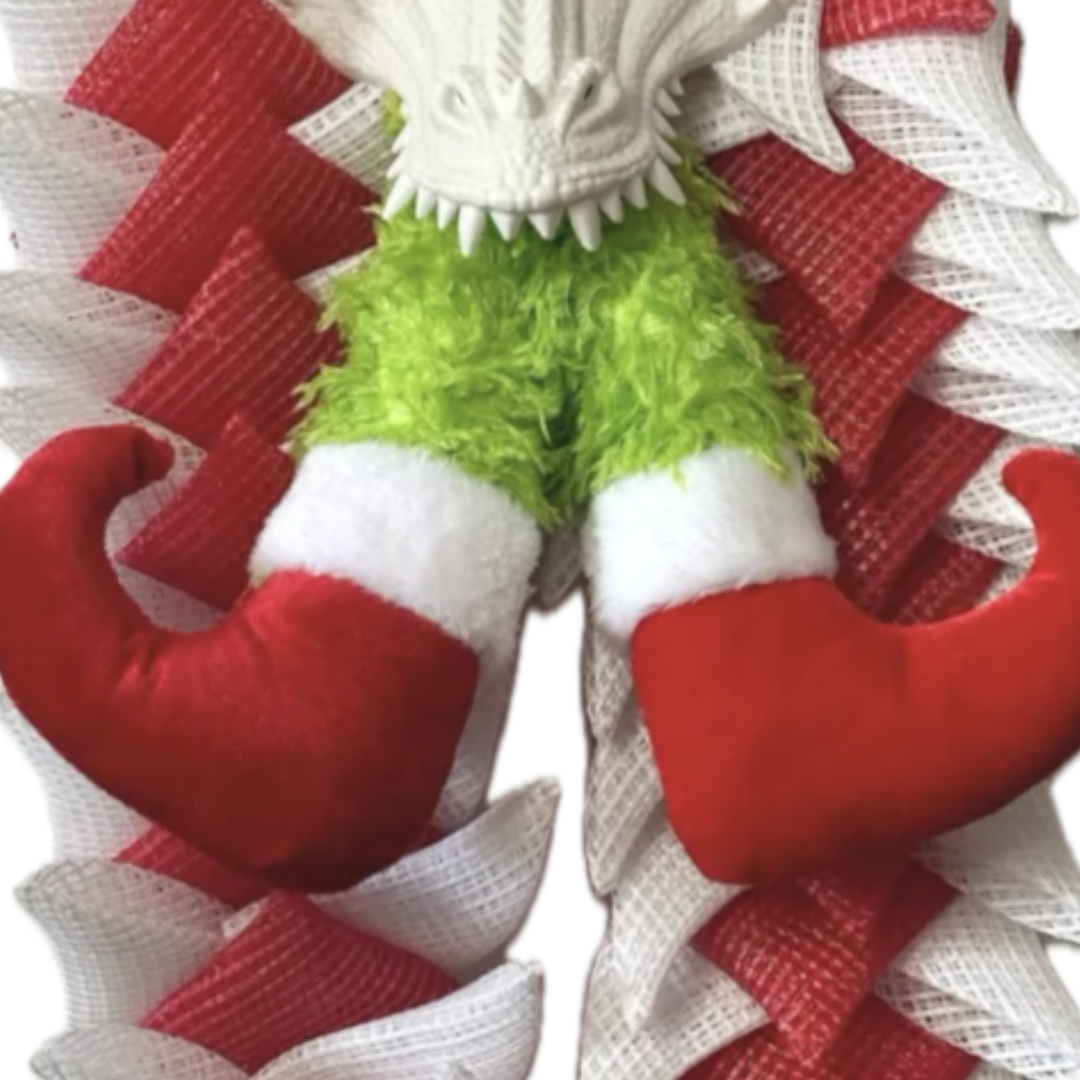 red and white deco mesh christmas dragon with elf legs in its mouth, focus on elf legs