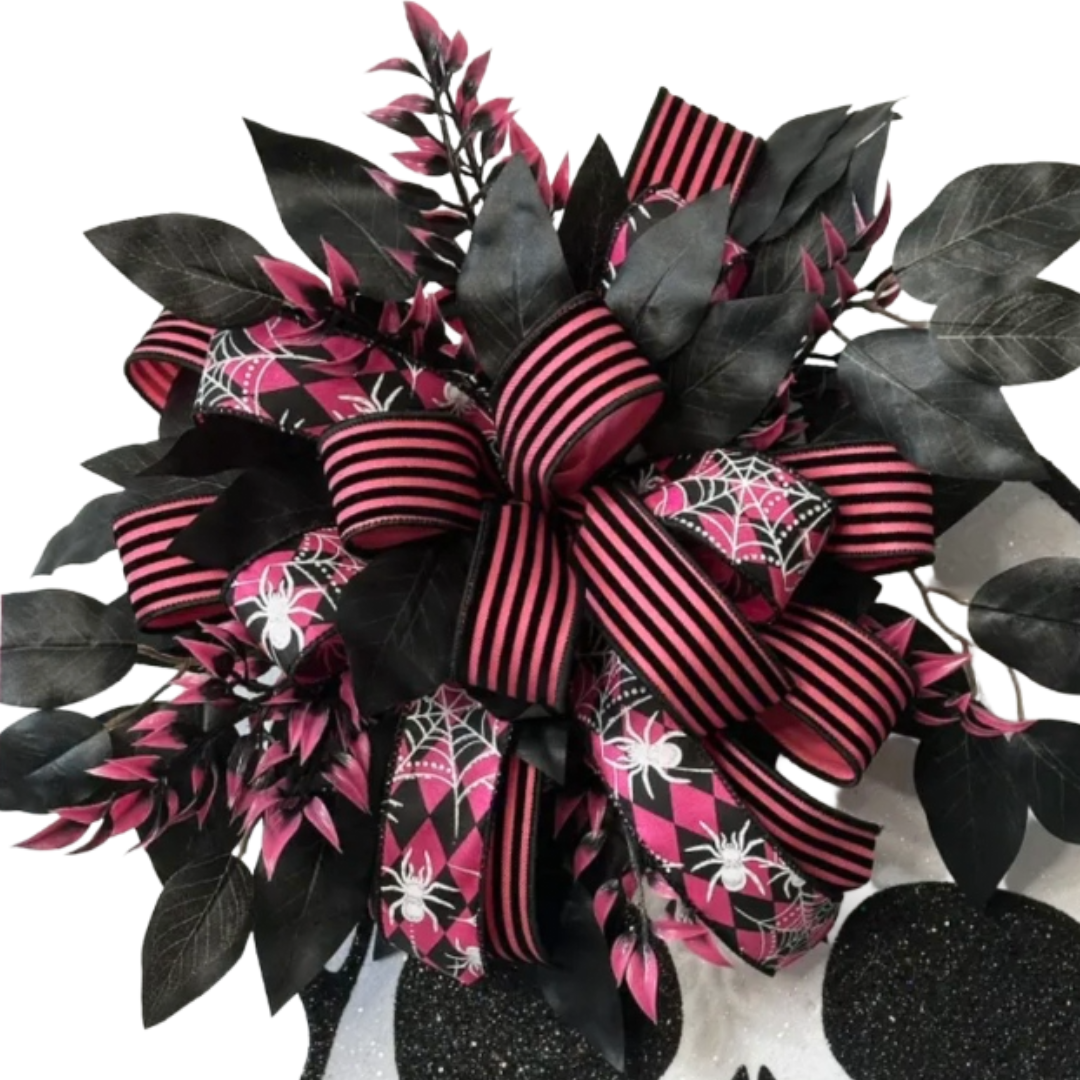 Halloween skeleton skull with pink and black ribbon and foliage, focus on the ribbon