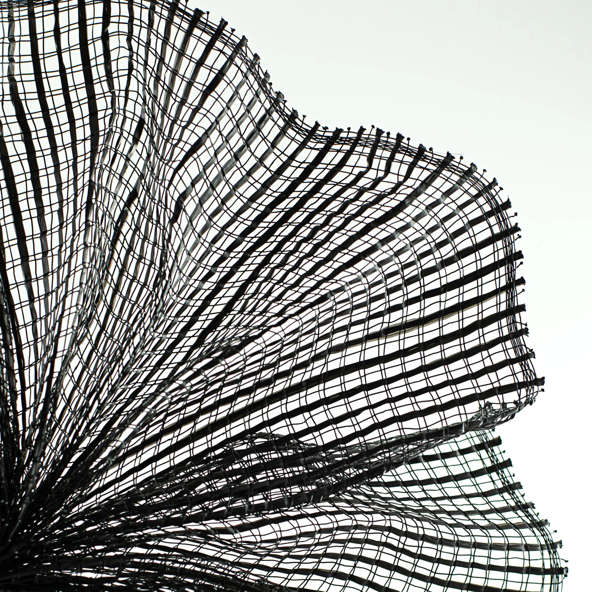 Close up of fanned weave of black horizontal wide stripe deco mesh carried by Monkey's Creations - MPN RE890002.
