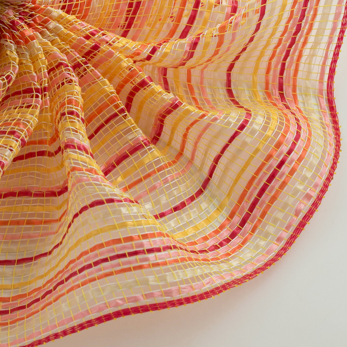 Close up of vertical wide stripe striation deco mesh weave with red, orange, yellow, creme and white stripes MPN RE13691F.