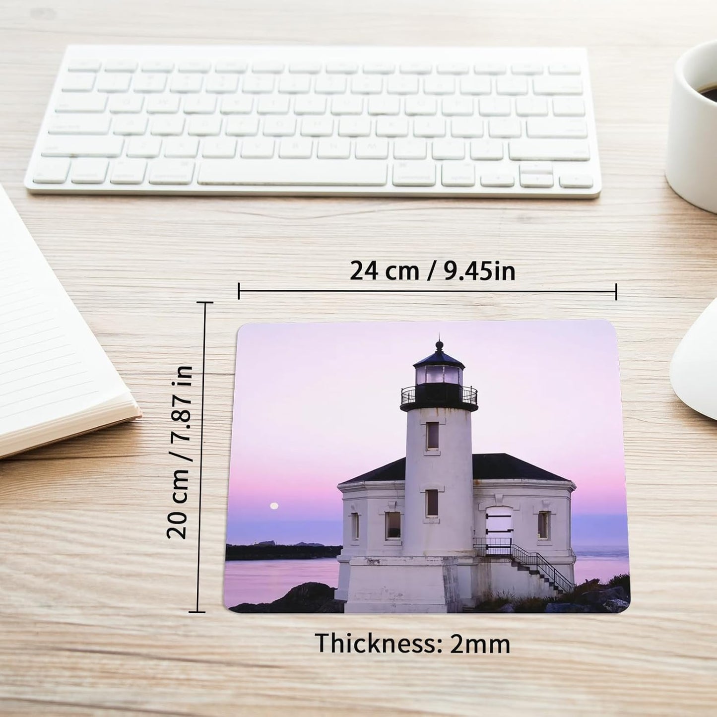 Mouse pad with lighthouse design on a desk, showing measurements and thickness.