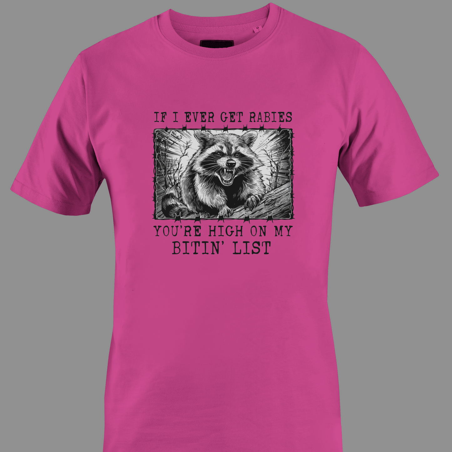 Dark pink t-shirt with a graphic of a raccoon and text rabies bite list 