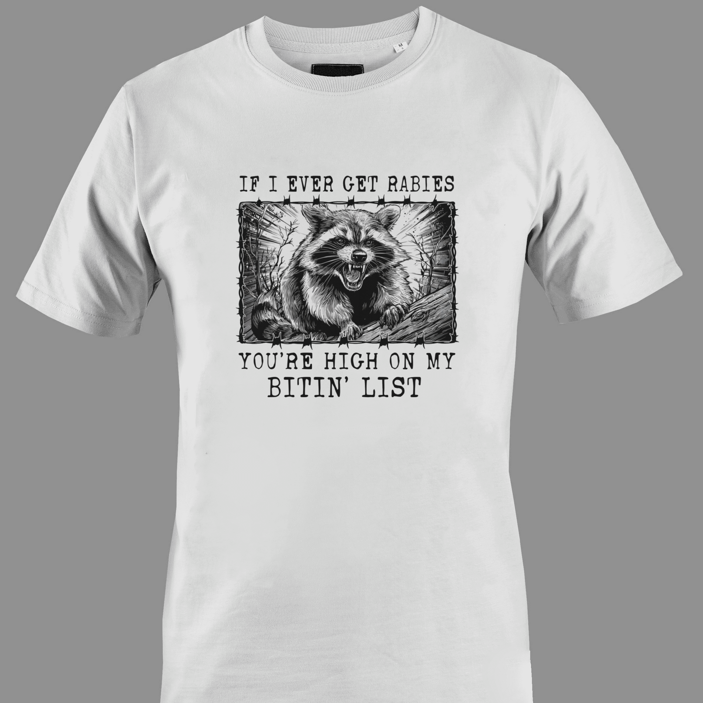 White t-shirt with a graphic of a raccoon and text rabies bite list 