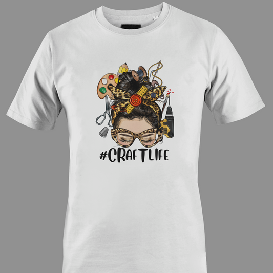 White t-shirt with a graphic design featuring a woman's face with craft supplies around her head, featuring the hashtag #CRAFTLIFE.