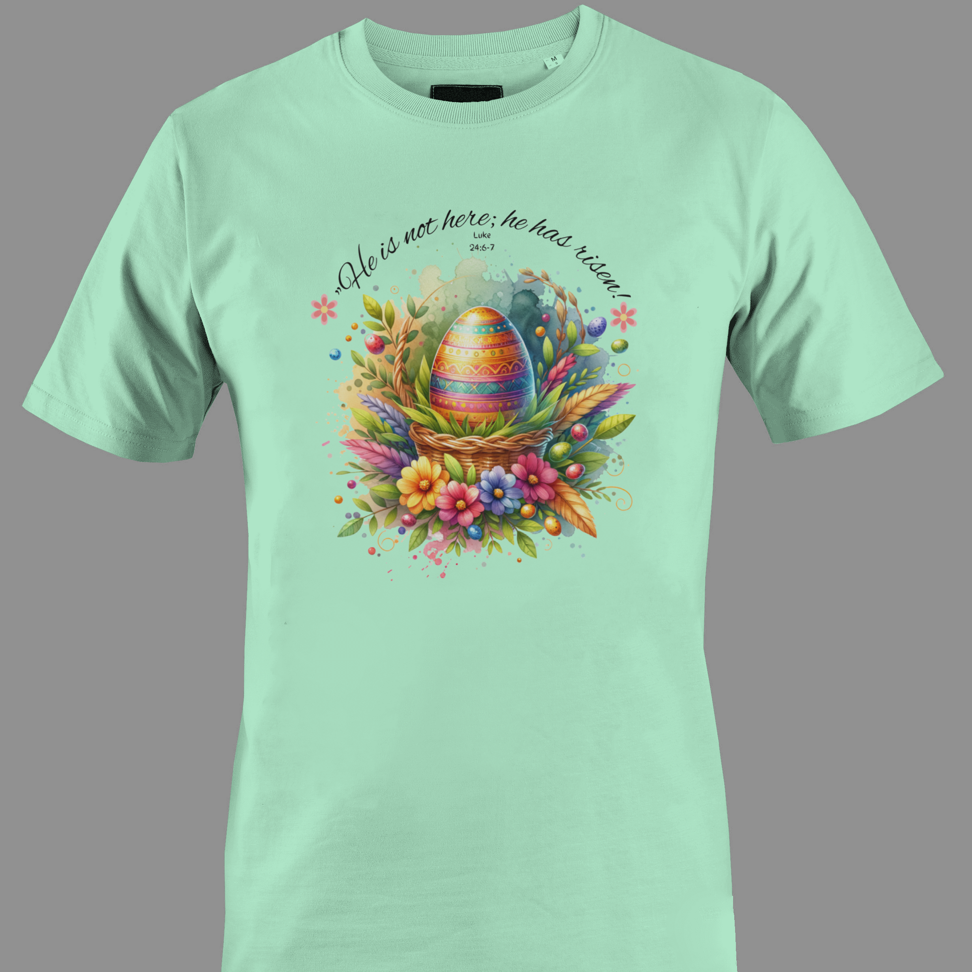 Light green t-shirt with Easter egg in a basket with flowers and leaves, featuring a religious quote.
