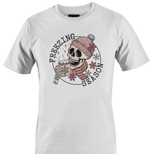 White t-shirt with a skull wearing a hat and scarf with a hot chocolate and the text "freezing season" by Monkey's Creations.