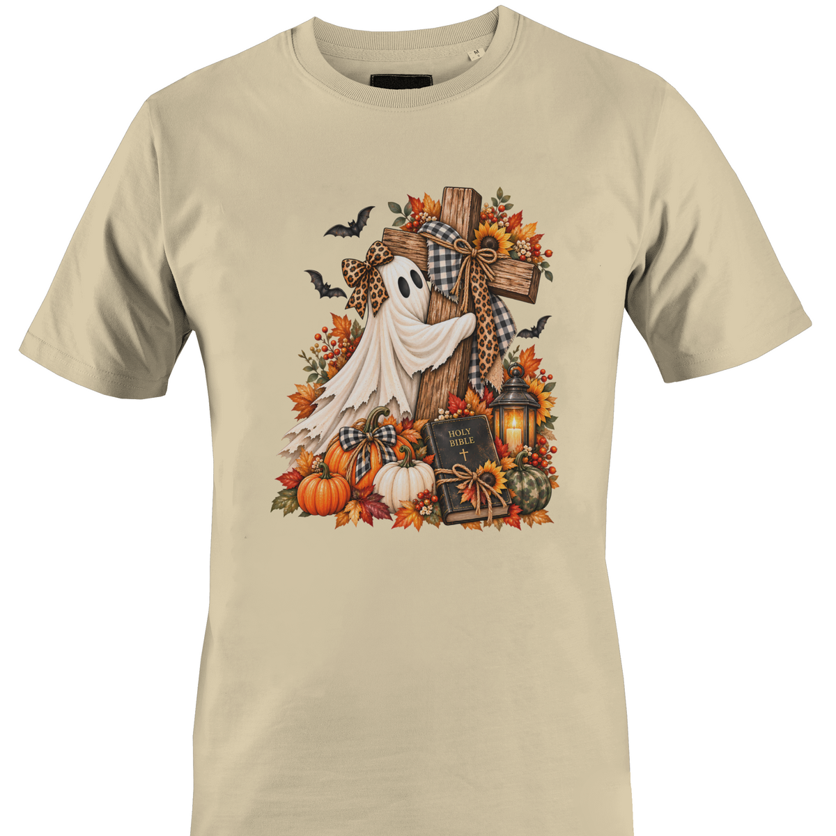 A beige crewneck t-shirt featuring a detailed autumn Halloween graphic with a white ghost draped over a wooden cross, surrounded by pumpkins, fall leaves, sunflowers, a lantern, and bats by Monkey's Creations.