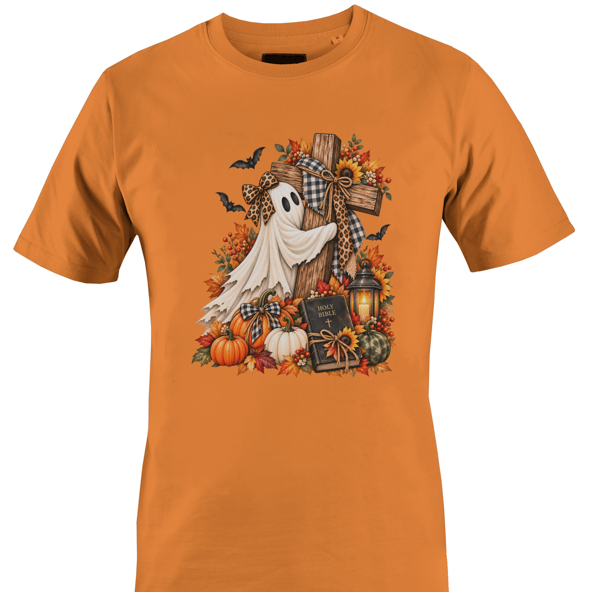 A orange crewneck t-shirt featuring a detailed autumn Halloween graphic with a white ghost draped over a wooden cross, surrounded by pumpkins, fall leaves, sunflowers, a lantern, and bats by Monkey's Creations.