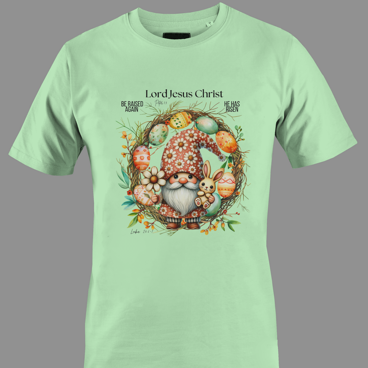 Light green t-shirt with an Easter gnome with a bunny, and Easter eggs surrounded by a wreath.