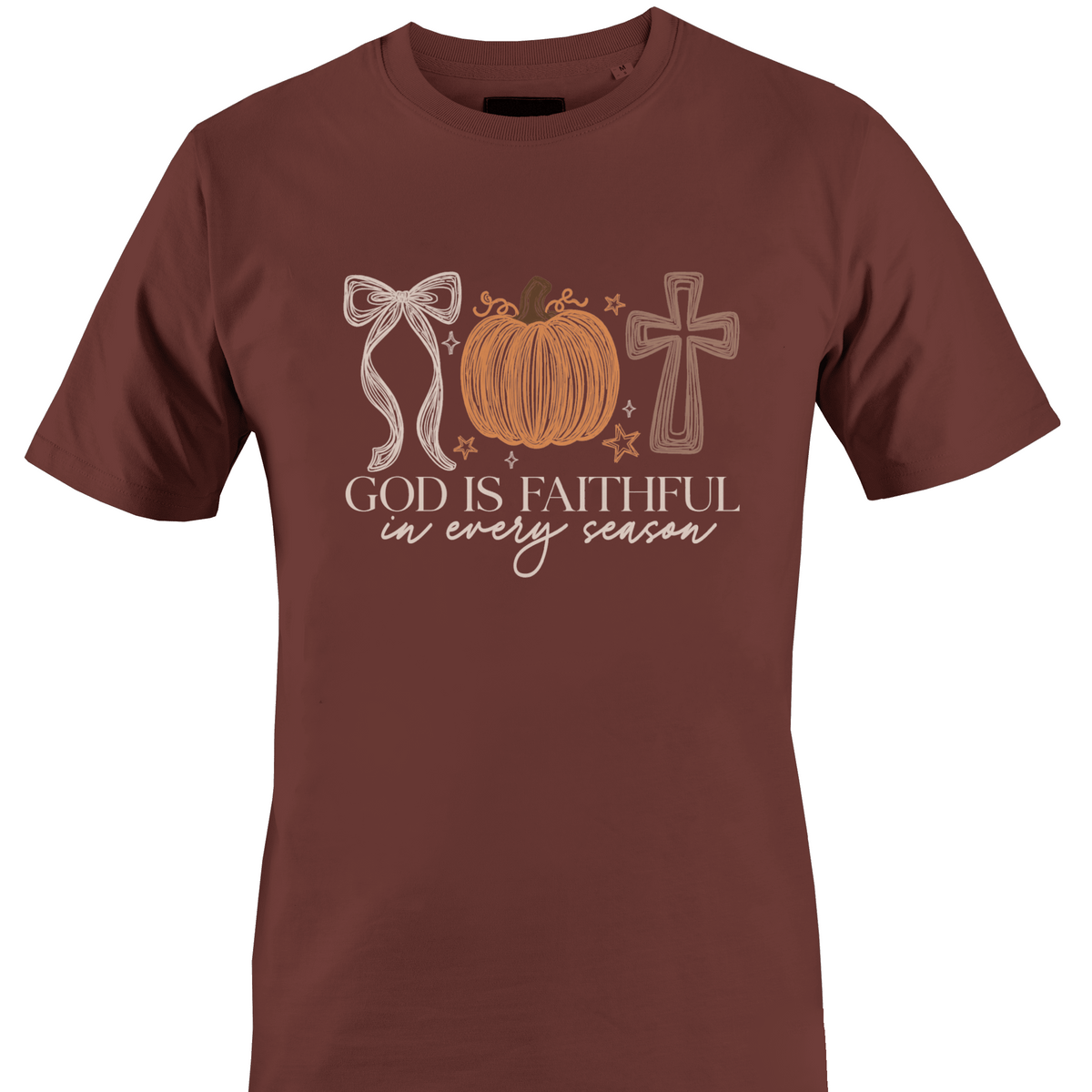A brown short-sleeve crewneck t-shirt featuring a graphic design on the front with a bow, a pumpkin, a cross, and the text 'GOD IS FAITHFUL in every season' by Monkey's Creations.