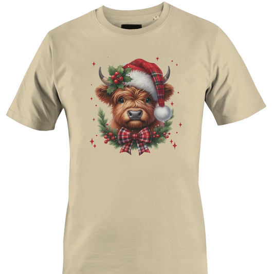 Tan t-shirt with a highland cow wearing a plaid santa hat with holly berries and a plaid bow by Monkey's Creations. 