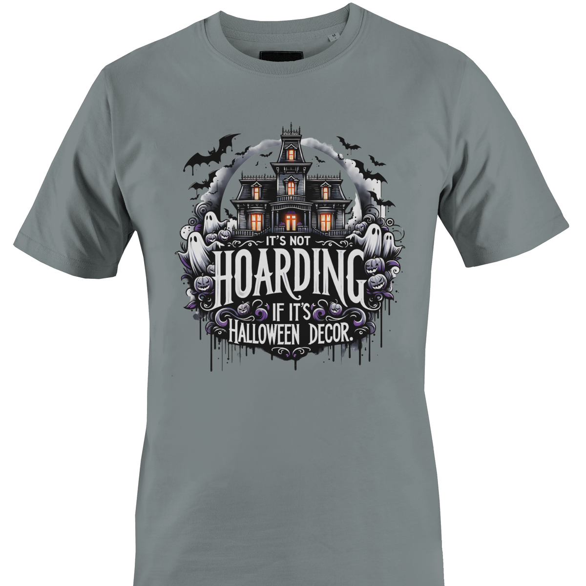 A grey short-sleeve crewneck t-shirt featuring a Halloween-themed graphic print on the front. The graphic shows a haunted house, ghosts, and purple flowers with the text 'IT'S NOT HOARDING IF IT'S HALLOWEEN DECOR' by Monkey's Creations.
