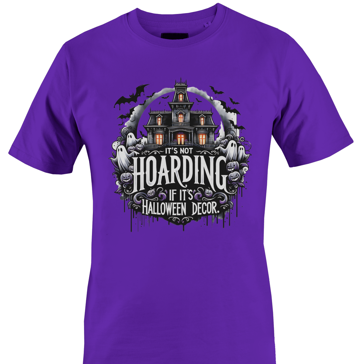 A purple short-sleeve crewneck t-shirt featuring a Halloween-themed graphic print on the front. The graphic shows a haunted house, ghosts, and purple flowers with the text 'IT'S NOT HOARDING IF IT'S HALLOWEEN DECOR' by Monkey's Creations.