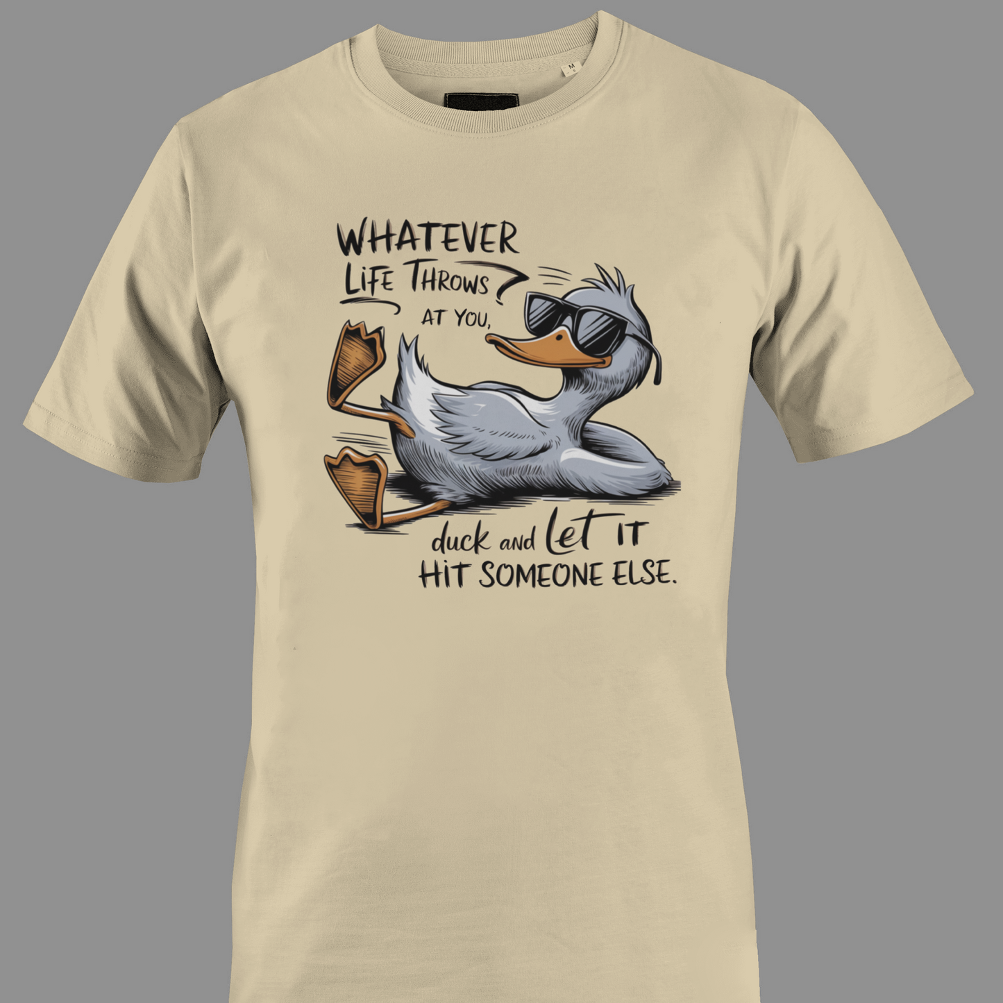 Beige t-shirt with a cartoon duck graphic and text whatever life throws at you