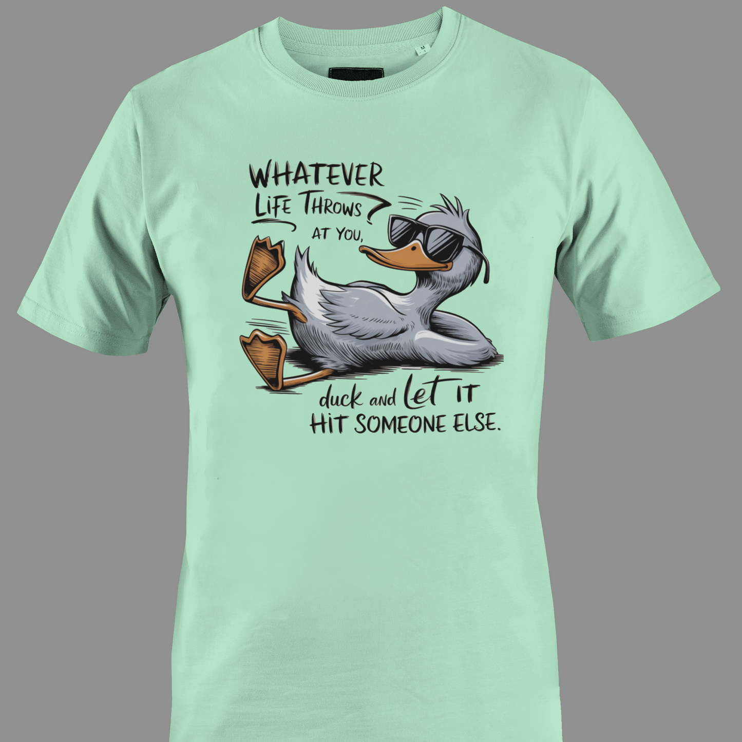 Light green t-shirt with a cartoon duck graphic and text whatever life throws at you