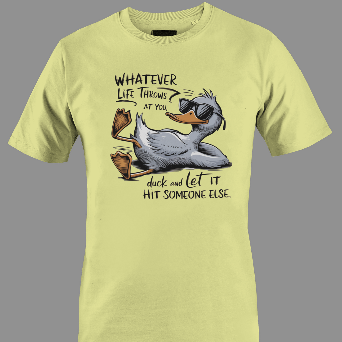 Light yellow t-shirt with a cartoon duck graphic and text whatever life throws at you