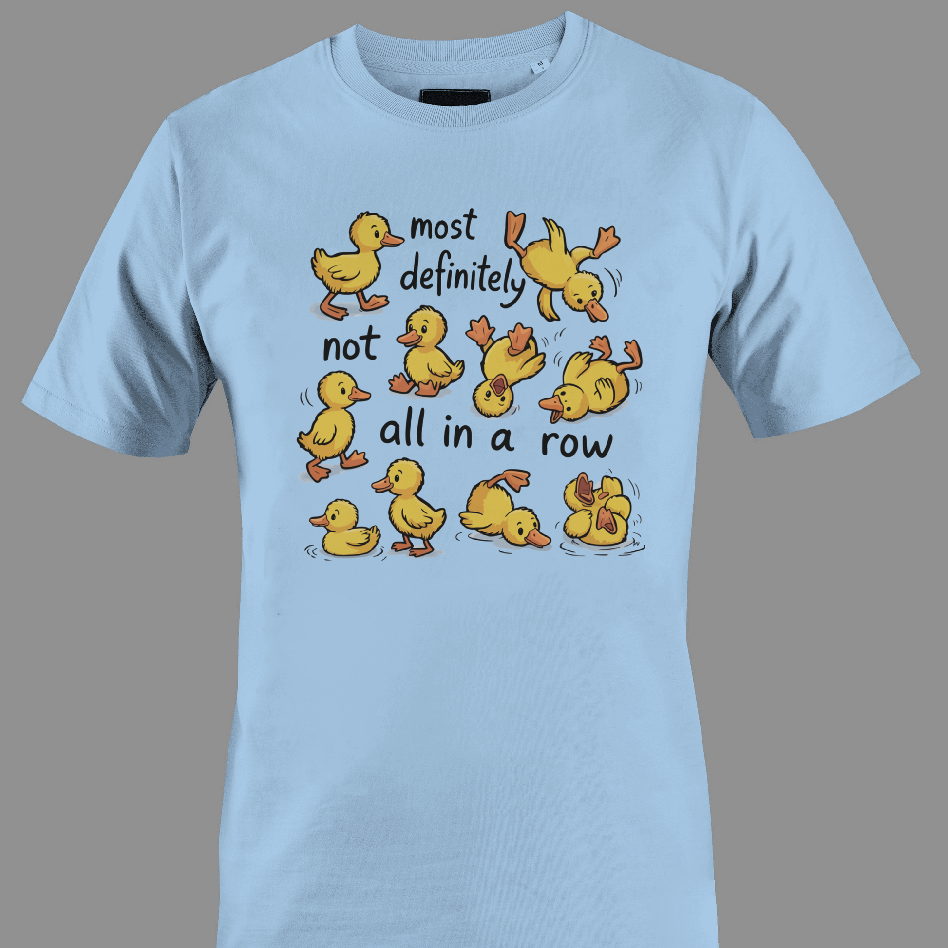 Light blue t-shirt with yellow ducklings and text most definitely not all in a row