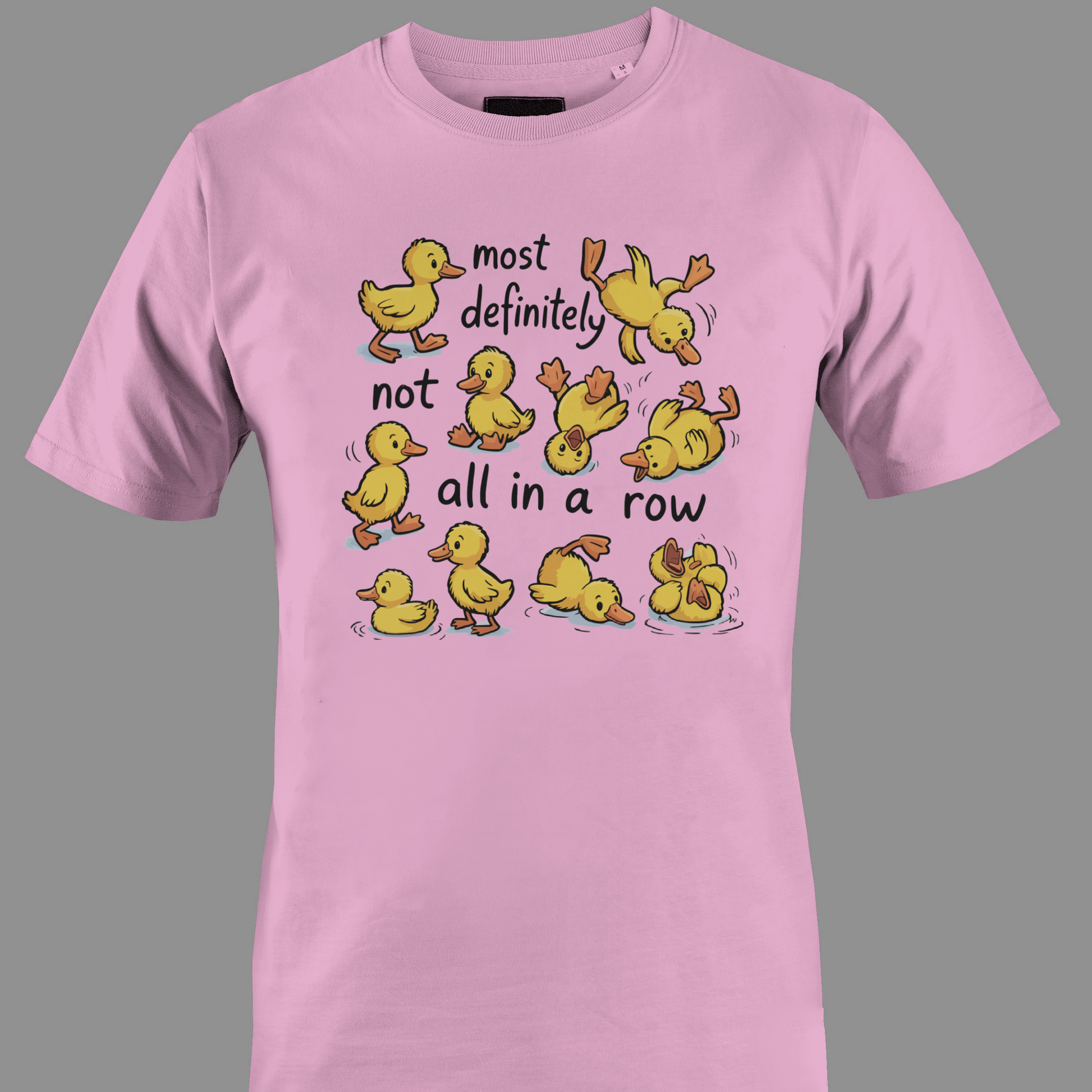 Light pink t-shirt with yellow ducklings and text most definitely not all in a row