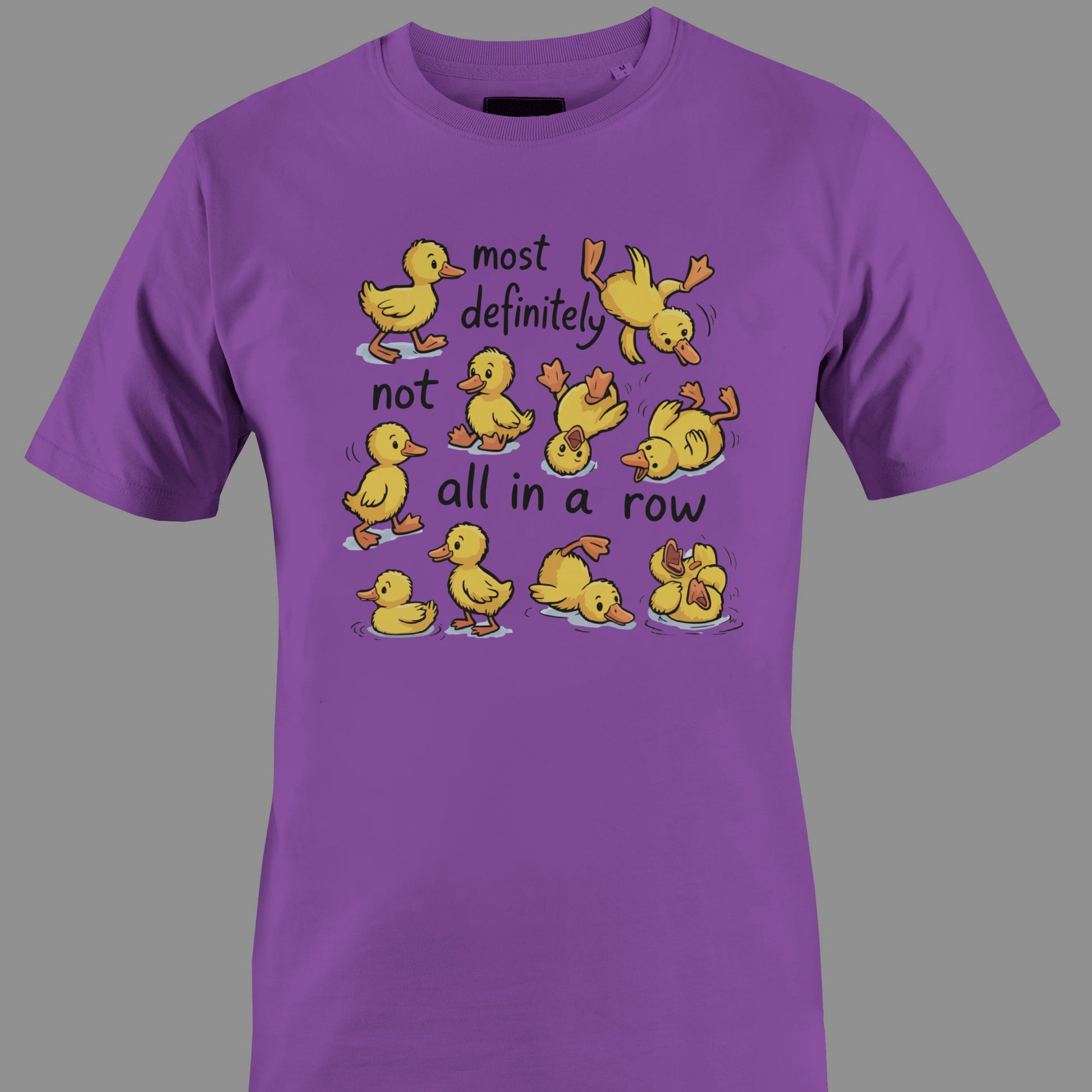 Purple t-shirt with yellow ducklings and text most definitely not all in a row