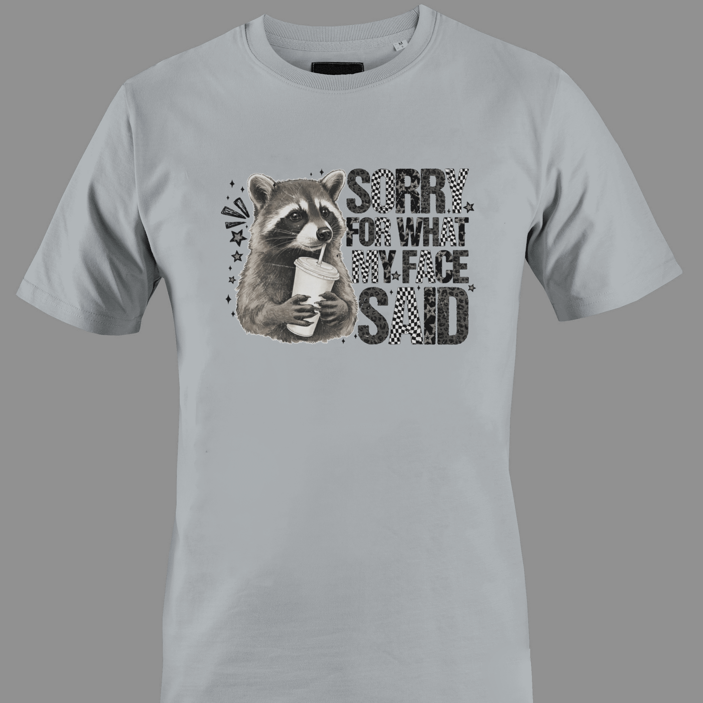 Light gray t-shirt with a raccoon graphic and text sorry for what  my face said