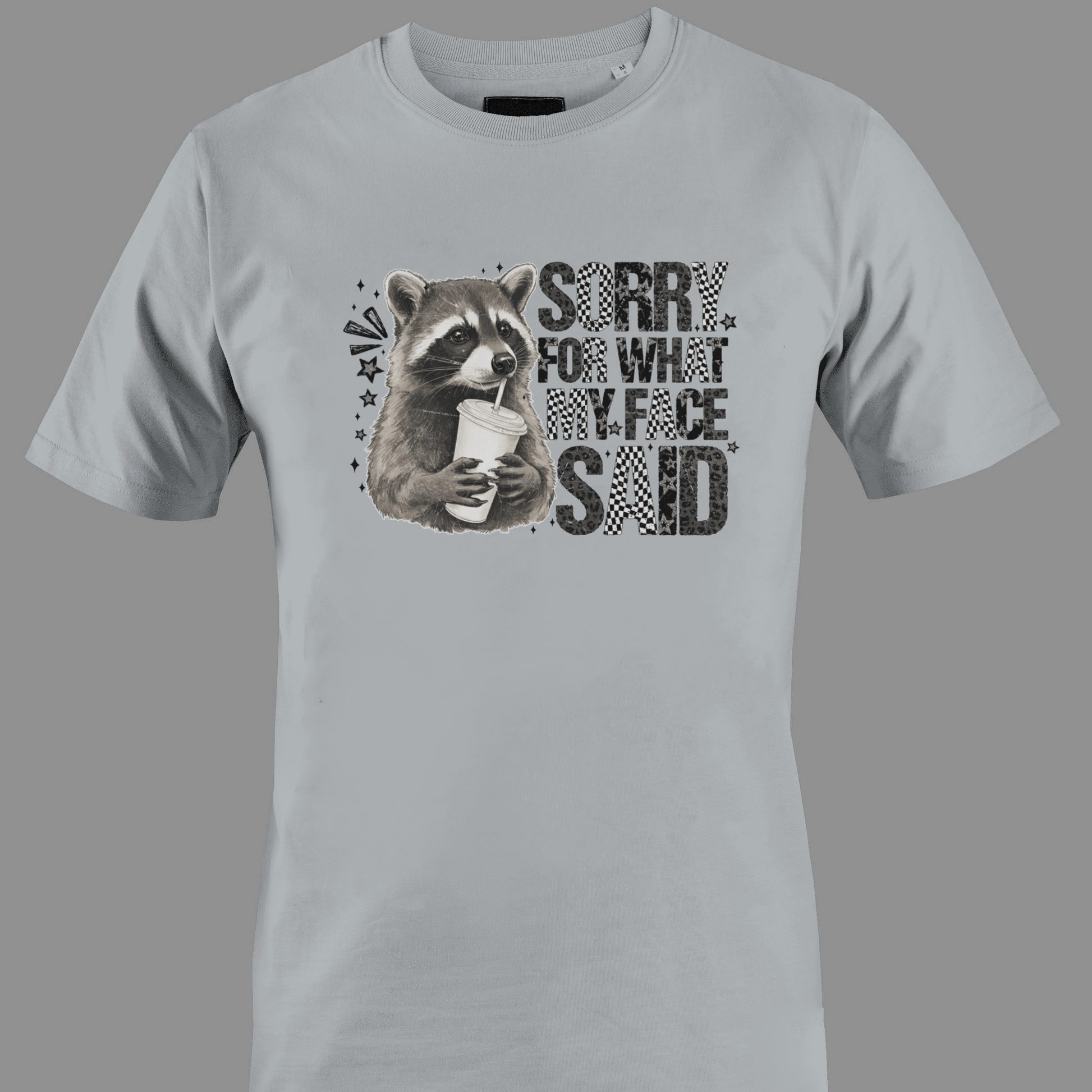 Light gray t-shirt with a raccoon graphic and text sorry for what  my face said
