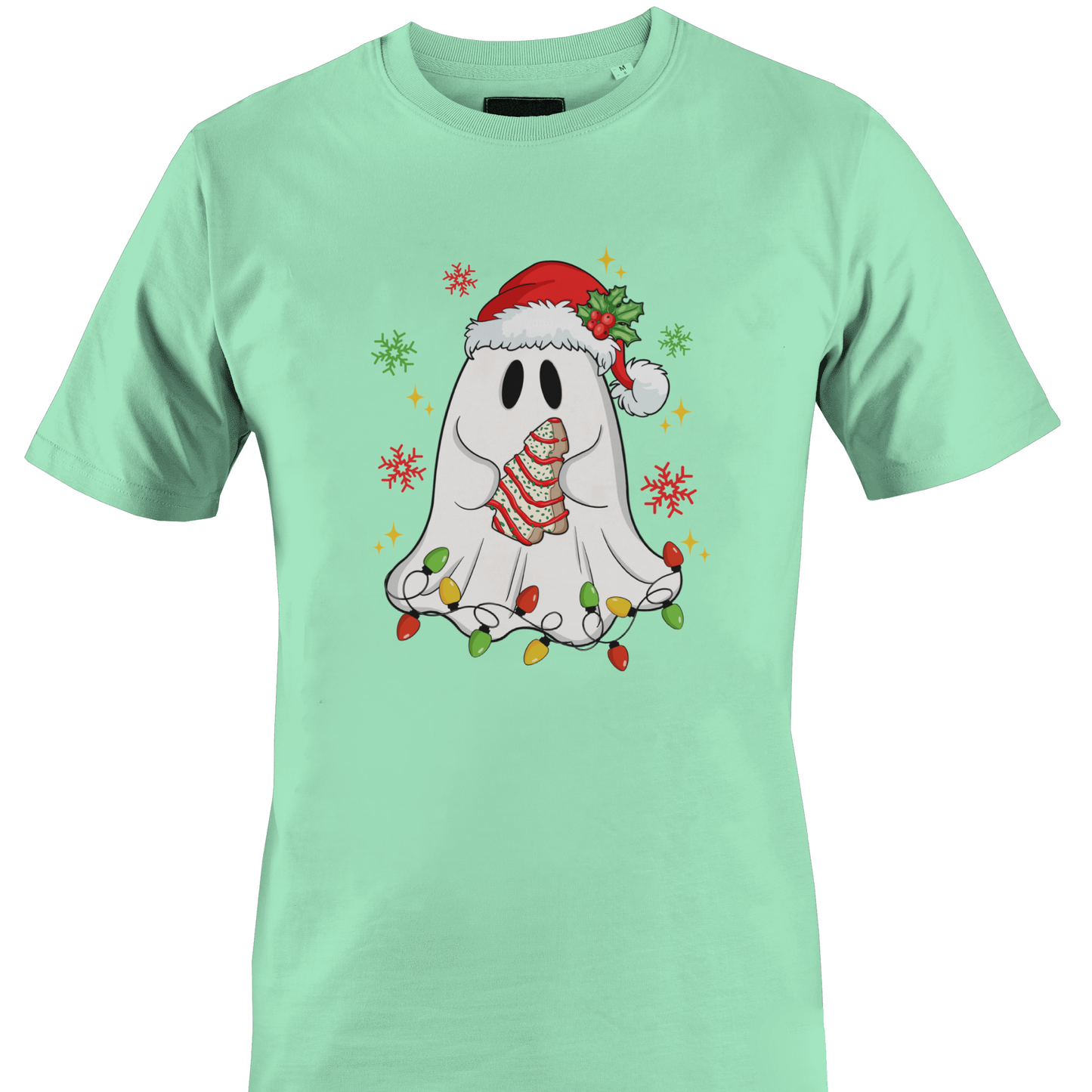A mint green short-sleeve crewneck t-shirt featuring a festive graphic of a cute white ghost wearing a red Santa hat and a striped red-and-white scarf, surrounded by colorful Christmas lights and snowflakes holding a cookie by Monkey's Creations. 