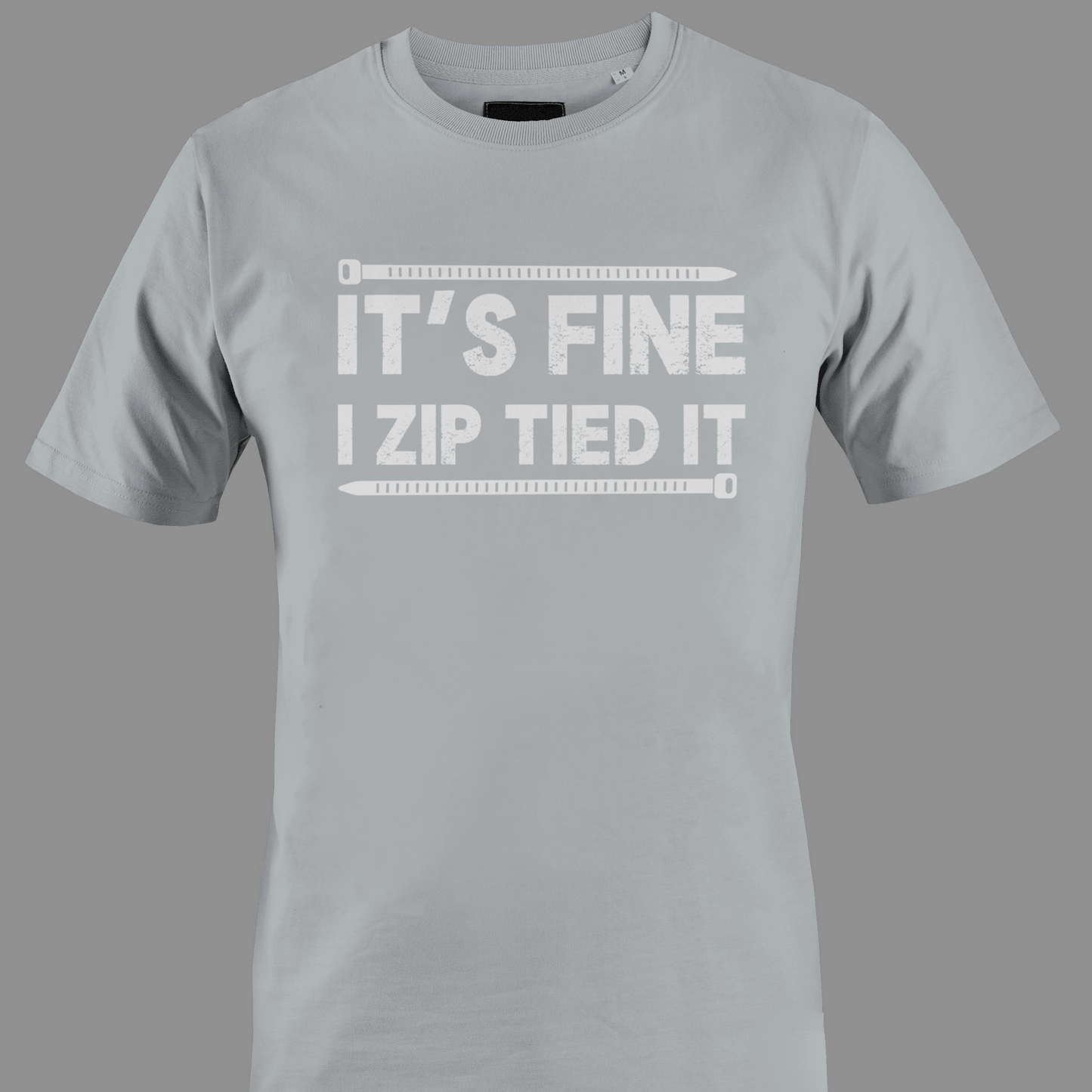 Light gray t-shirt with white text 'IT'S FINE I ZIP TIED IT' 