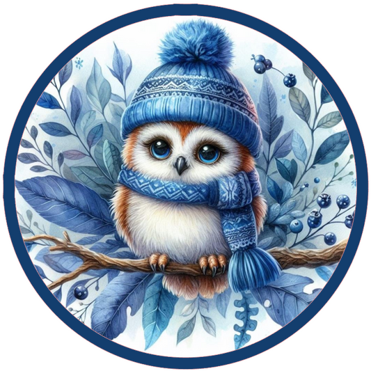 Round metal wreath sign of an owl wearing a blue winter hat and scarf on a branch with leaves and berries by Monkey's Creations.