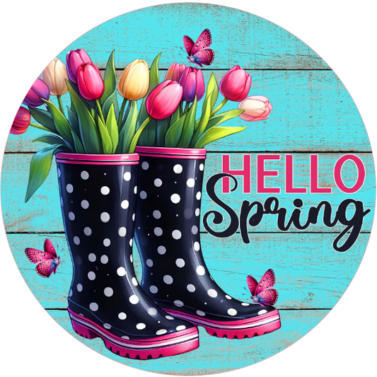 Round metal wreath sign with polka dot rain boots, tulips, and 'Hello Spring' text on a blue wooden background.