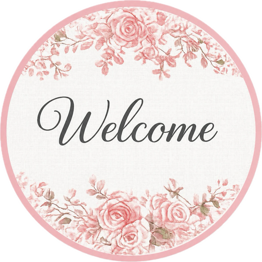 Round metal wreath sign by Monkey's Creations featuring a white background with black "welcome" text and light pink chinoiserie style roses and a border