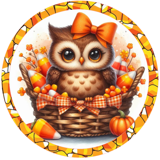 Owl with an orange bow in a basket surrounded by candy corn and autumn elements on a white background