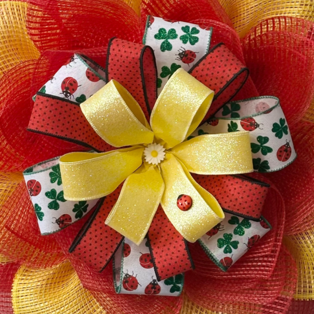 Red and yellow deco mesh flower wreath with a ribbon center and spring elements by Monkey's Creations