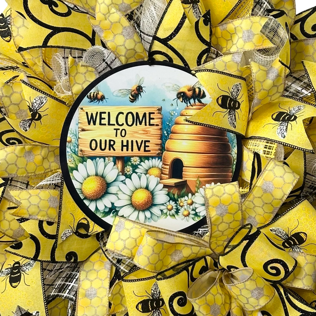 Deco mesh and ribbon wreath with yellow and black bee design, featuring a 'Welcome to Our Hive' wreath sign designed by Monkey's Creations.