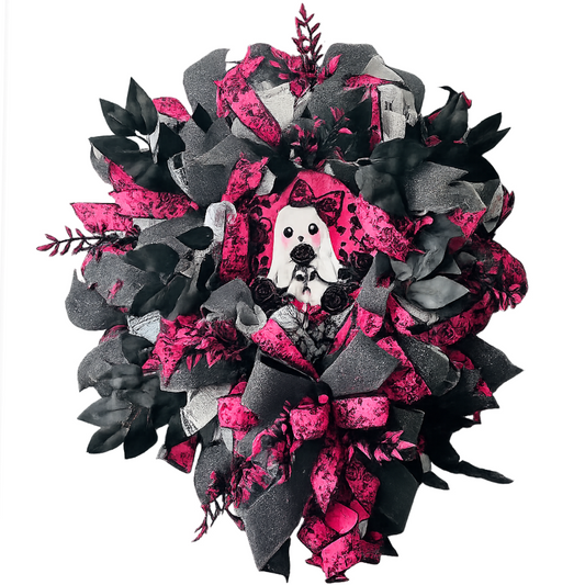 A deco mesh and ribbon Halloween wreath featuring a black and pink theme with a ghost metal wreath sign and pink and black picks by Monkey's Creations. 