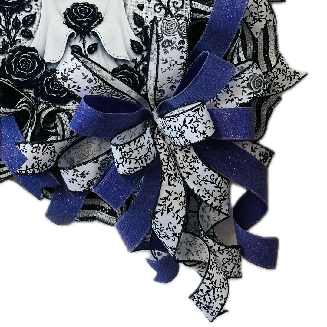 A deco mesh and ribbon wreath featuring a cute ghost with roses metal wreath sign black and white deco mesh and ribbon with purple ribbon by Monkey's Creations. 