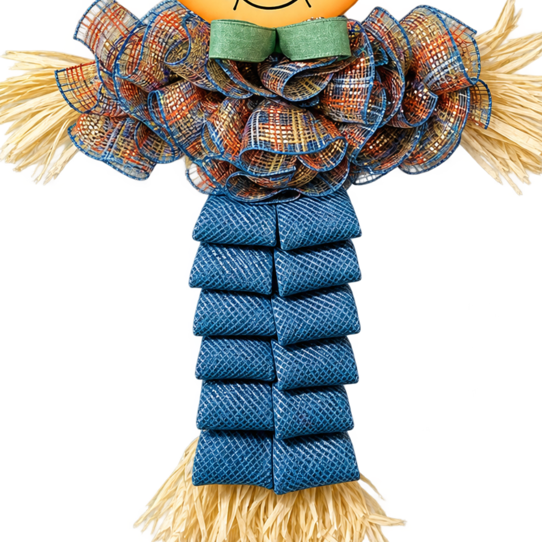 A decorative deco mesh autumn scarecrow door hanger with a round character face, brown hat with a yellow flower, rafia accents, an orange and smoke blue plaid shirt and smoke blue pants by Monkey's Creations. 