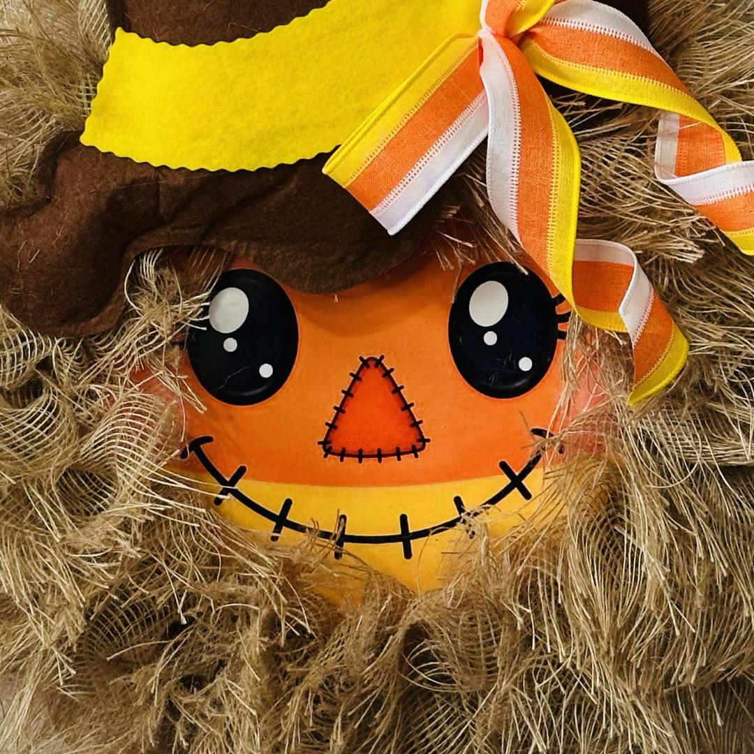 Autumn and Halloween candy corn themed scarecrow wreath with a candy corn scarecrow metal wreath sign center, frayed edge burlap, a felt hat and a candy corn colored bow by Monkey's Creations. 
