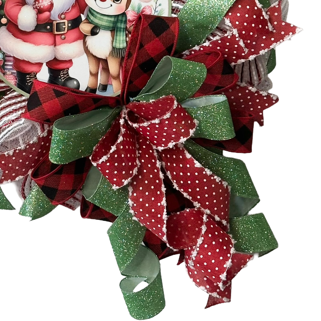 Deco mesh and wired ribbon wreath featuring red and green Christmas colors and a classic Santa and "Rudolph" inspired metal wreath sign center by Monkey's Creations. 