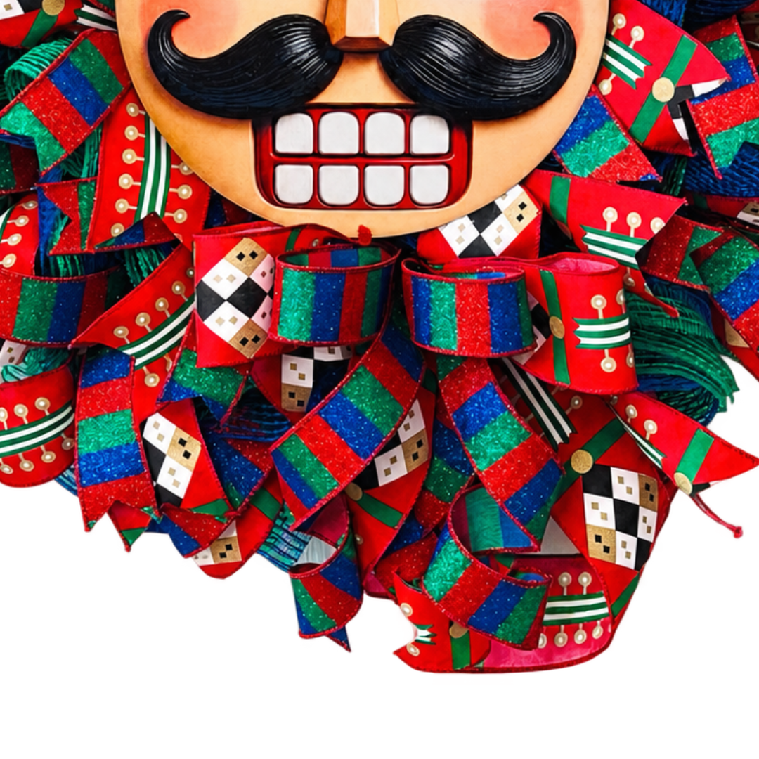 Deco mesh and ribbon nutcracker wreath in red, blue and green with a classic nutcracker face as the wreath center and a faux velvet hat by Monkey's Creations. 