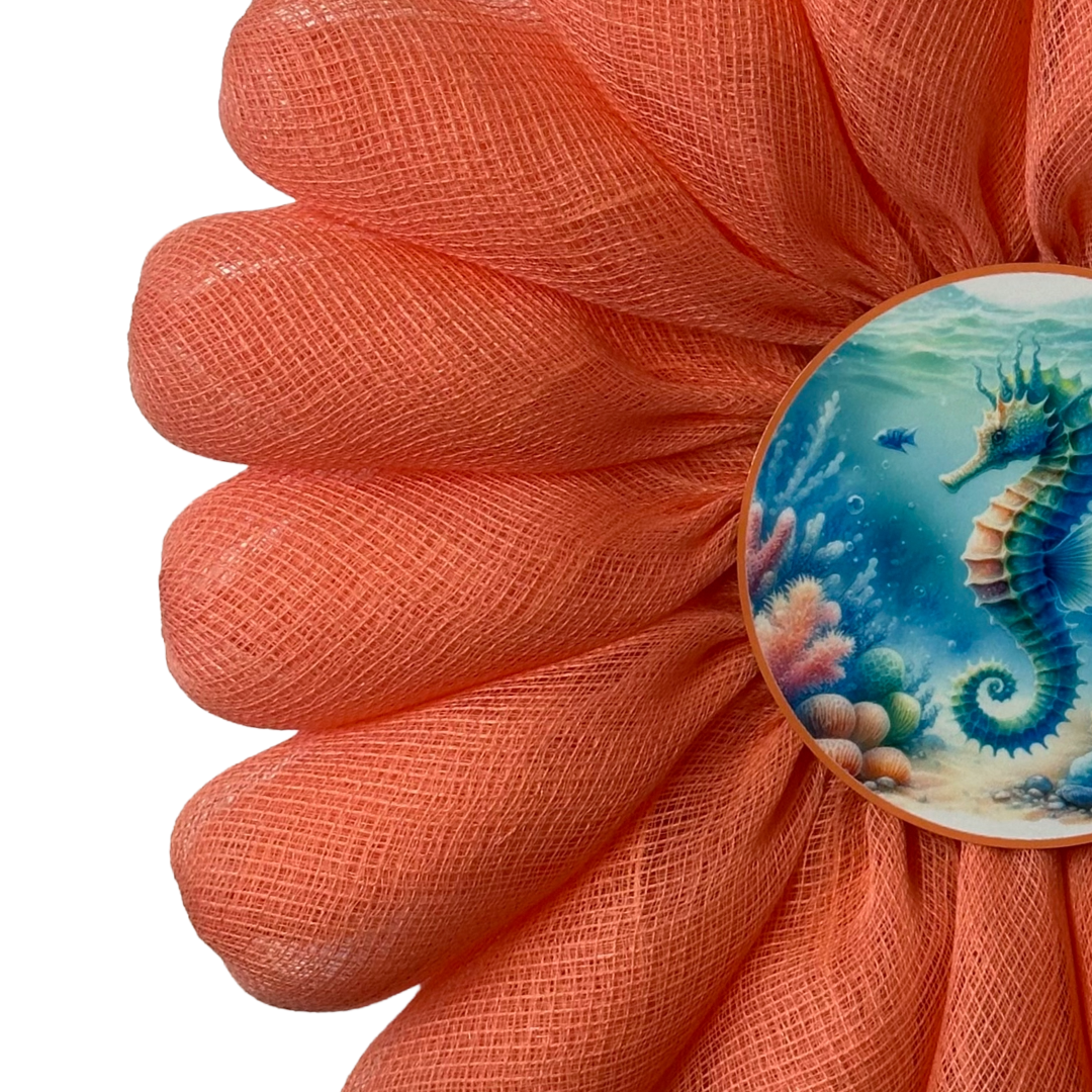 Coral-colored flower wreath with a seahorse design in the center by Monkey's Creations