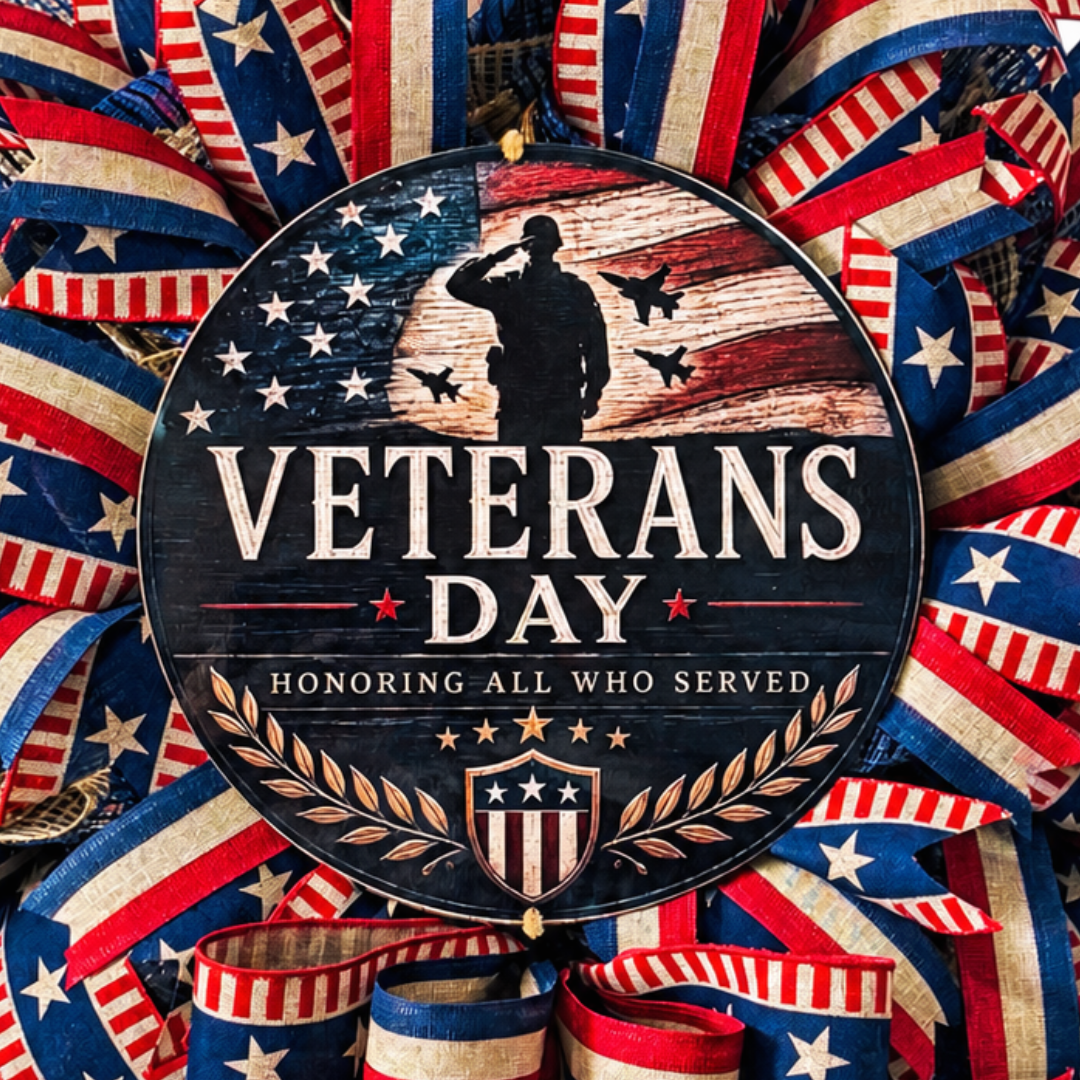 Deco mesh and ribbon wreath by Monkey's Creations featuring patriotic red, natural and navy blue Americana colors with a "Veterans Day - honoring all who served" metal wreath sign center.