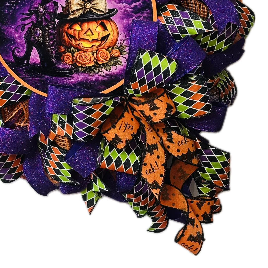 Orange, purple, green and black Halloween deco mesh and ribbon wreath featuring colorful bow and a metal wreath sign with the text "if the shoe fits" by Monkey's Creations.