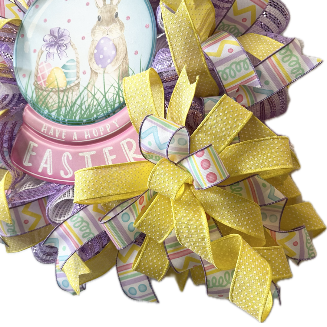 Decorative wreath with Easter-themed elements and a large yellow bow on a white background.